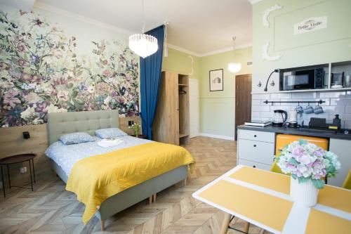 a small bedroom with a bed and a kitchen at Petite Visite No 18A i 18B in Toruń