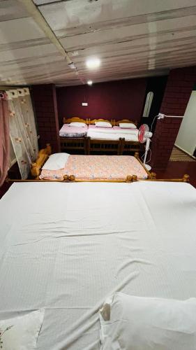a room with two beds in a room withthritisthritisthritisthritisthritisthritisthritis at Coorg Tribal Land homestay in Kushālnagar