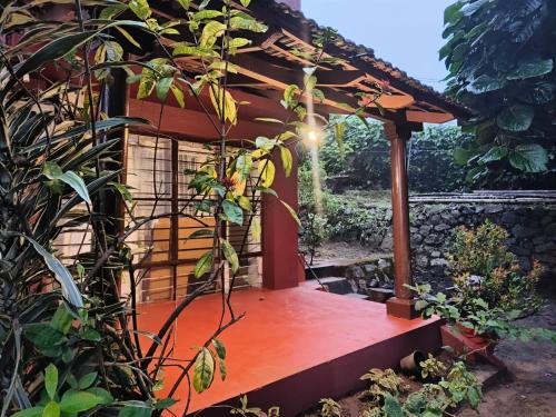 a pergola with a bench in a garden at Coorg Tribal Land homestay in Kushālnagar