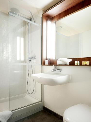 une salle de bain avec un lavabo et une douche dans l'établissement Campanile Poitiers - Site du Futuroscope, à Chasseneuil-du-Poitou