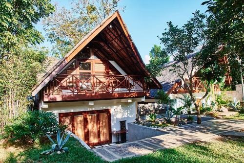 a house with a gambrel roof with a porch at The Zen Villas Resort in Lipa