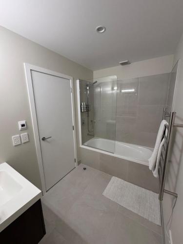 a white bathroom with a shower and a bath tub at Queenstown Retreat in Queenstown