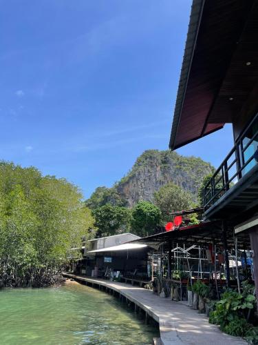 a building next to a river with a mountain in the background at Social Quarters Blanco - Youth Hostel 18 to 35 Only in Railay Beach