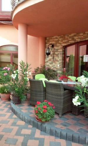 a patio with a table and chairs and flowers at Alba Regia Pansion Egri in Jahodná