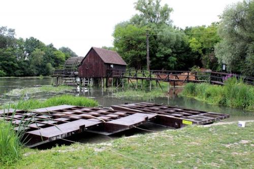 a group of b barges in a river with a barn at Alba Regia Pansion Egri in Jahodná