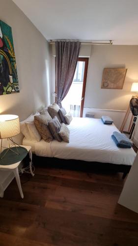 une chambre avec un grand lit avec une fenêtre dans l'établissement Centre d'Aix - charmant appartement 1 chambre Pythagore avec parking, à Aix-en-Provence