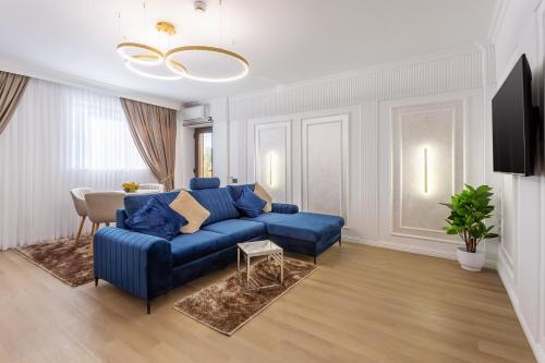 a living room with a blue couch and a table at Crystal Luxury in Craiova