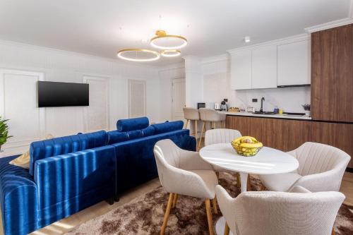 a living room with a blue couch and a table at Crystal Luxury in Craiova