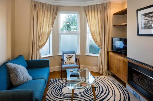 a living room with a blue couch and a tv at Rugby Lodge in Dublin