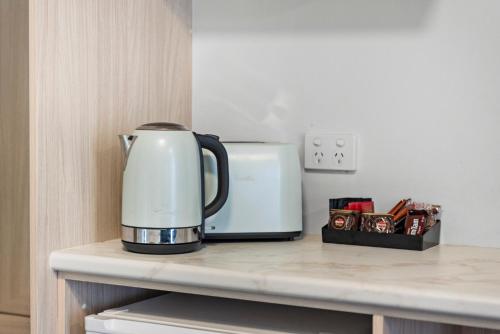 a coffeemaker sitting on a counter next to a microwave at Bomaderry Motor Inn in Nowra