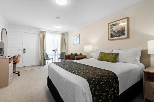 a hotel room with a bed and a desk at Bomaderry Motor Inn in Nowra