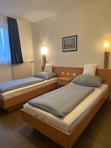 two beds in a hotel room with lights on at Hotel Am Vogelsanger Weg in Düsseldorf