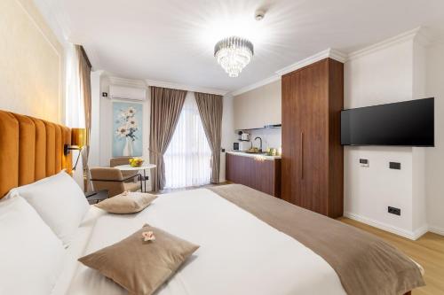 a bedroom with a large bed with a flat screen tv at Crystal Luxury in Craiova