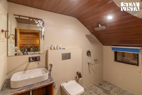 a bathroom with a sink and a toilet at StayVista at Amanat with BBQ, WiFi in Pahalgām