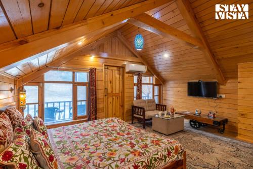 a bedroom with a bed and a tv in a room at StayVista at Amanat with BBQ, WiFi in Pahalgām