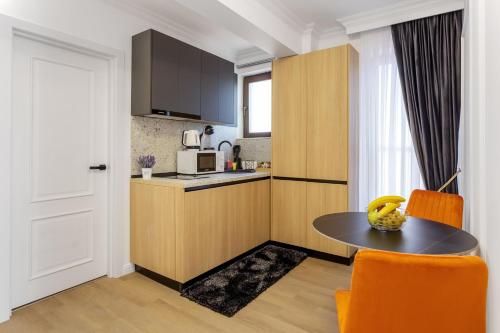 a kitchen with a table and orange chairs in a room at Crystal Luxury in Craiova