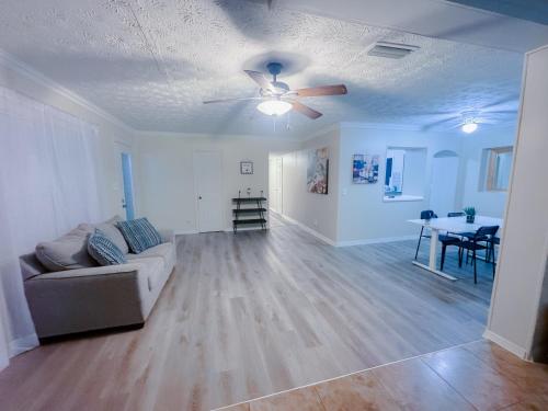 a living room with a couch and a ceiling fan at Cozy House St Johns Bluff in Jacksonville