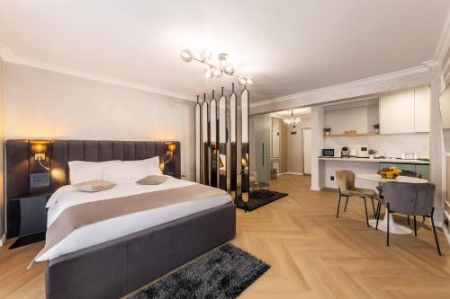 a bedroom with a large bed and a dining room at Crystal Luxury in Craiova