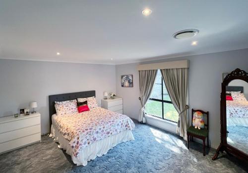 a bedroom with a bed and a mirror at Cozy on north in Armidale