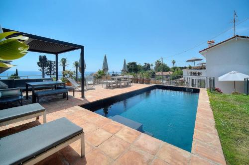 - une piscine dans un jardin avec une table et des bancs dans l'établissement Kathleen CANNES-GOLFE JUAN, à Vallauris