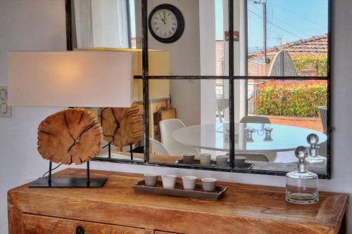 un miroir au-dessus d'une commode en bois avec une lampe dans l'établissement Kathleen CANNES-GOLFE JUAN, à Vallauris