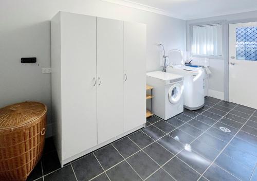 a bathroom with a sink and a washing machine at Cozy on north in Armidale