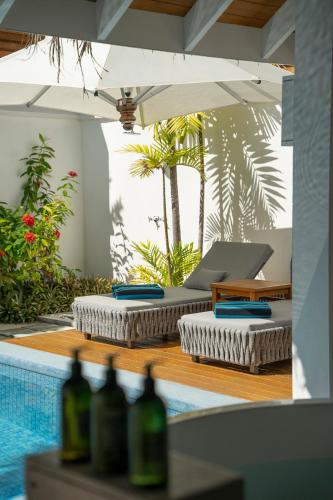 a pool with two umbrellas and some bottles of wine at Velassaru Maldives in South Male Atoll