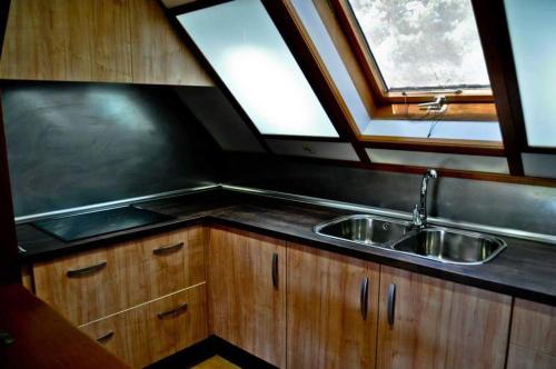 a kitchen with a sink and two windows at Camping Caravaning Cuenca in Cuenca