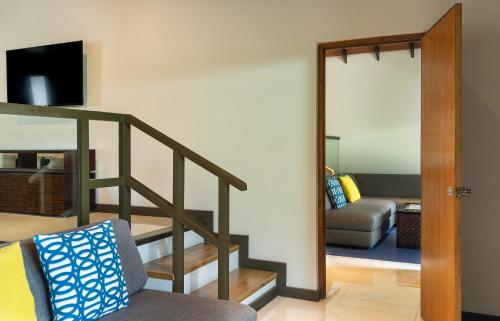 a stairway leading to a living room with a couch at Velassaru Maldives in South Male Atoll