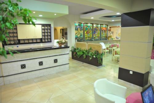 a restaurant with a waiting area with tables and chairs at Anseli Hotel in Kremasti