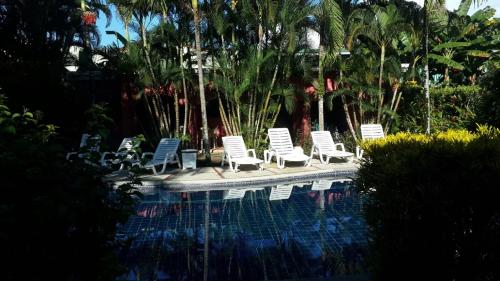 un grupo de sillas sentadas junto a una piscina en Hotel El Paraiso Escondido - Costa Rica, en Jacó