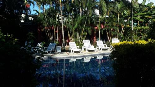 a group of chairs sitting next to a swimming pool at Hotel El Paraiso Escondido - Costa Rica in Jacó