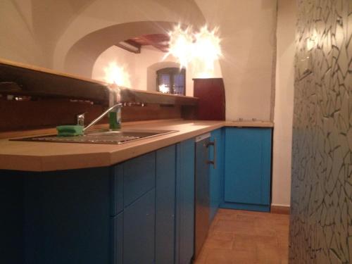una cocina con armarios azules y fregadero en VIP MiKU apartman 1, en Mikulov