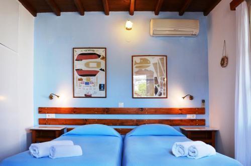 a bedroom with a blue bed and two towels at Villa Pinelopi in Mýkonos City