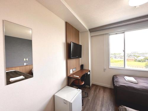 a small room with a bed and a mirror at Tabist Tsukuba Sky Hotel in Tsukuba