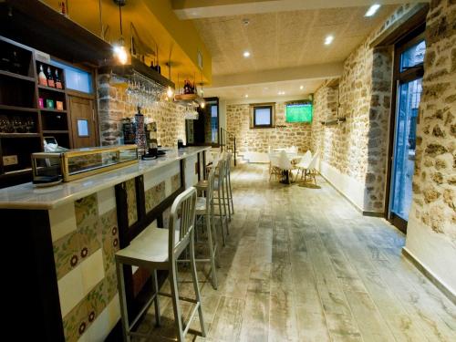 a restaurant with brick walls and a bar with chairs at La Casa de Beli in Tardajos