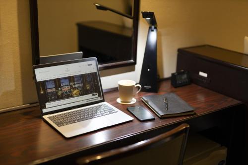 a laptop computer sitting on top of a wooden desk at Shinagawa Prince Hotel East Tower in Tokyo