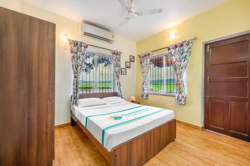 a bedroom with a bed and a door and windows at Casa De Fazenda - Farmhouse, Diwar Island in Divar