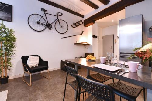 une salle à manger avec une table et un vélo suspendu au mur dans l'établissement Gite See You Soon - Le Loft, à Colmar