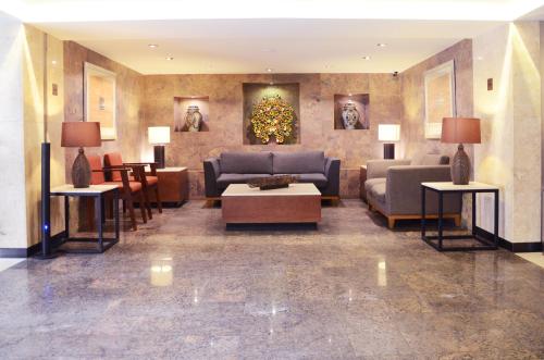 un hall avec des canapés et des tables dans un bâtiment dans l'établissement Hotel Marlowe Centro Histórico, à Mexico
