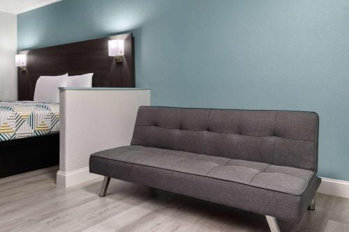 a couch in a room with a bed at Travelodge by Wyndham Lemoore Near Naval Air Station in Lemoore