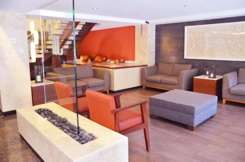 a lobby with a couch and chairs and a table at Hotel Marlowe Centro Histórico in Mexico City