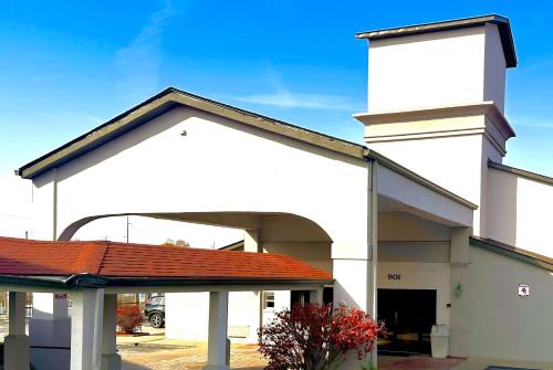 a large white building with a red roof at Ramada by Wyndham Columbia in Columbia
