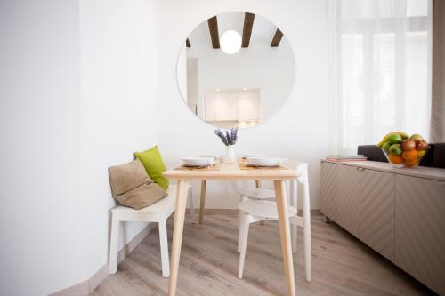 uma sala de jantar com uma mesa e um espelho em Apartamentos Wallace em Valência