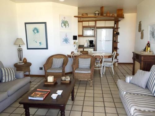Una sala de estar con un sofá y sillas y una mesa. en Frente Para O Mar, en Río de Janeiro