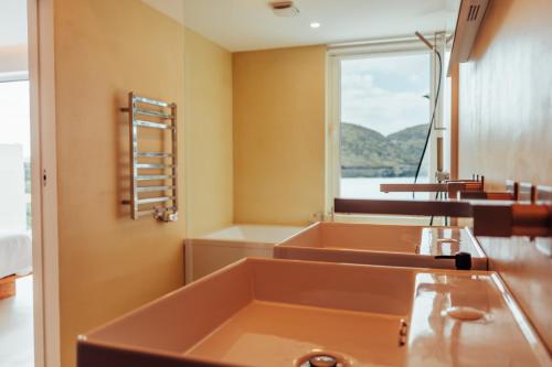 a bathroom with a row of sinks and a window at Silveira Bay Lounge Retreat in Angra do Heroísmo
