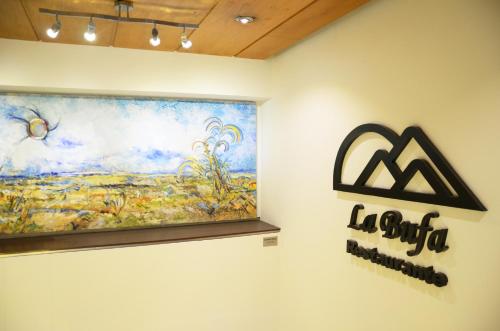 a painting on a wall with a sign on it at Hotel Marlowe Centro Histórico in Mexico City
