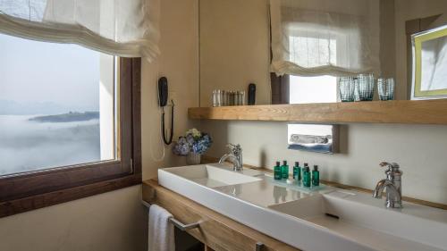 a bathroom with a sink and a mirror at Puebloastur Eco Resort Hotel & Spa in Cofiño