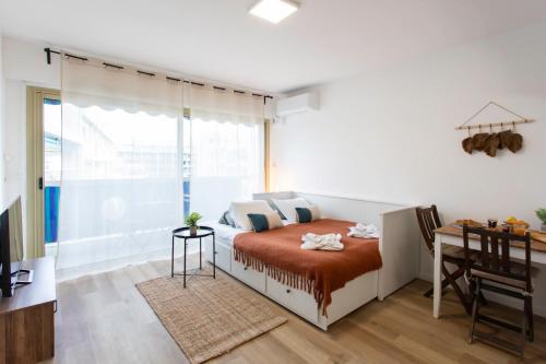 une chambre avec un lit, un bureau et une fenêtre dans l'établissement A1 - Studio Antibes Centre 5 min to Sea - AC & Balcony, à Antibes