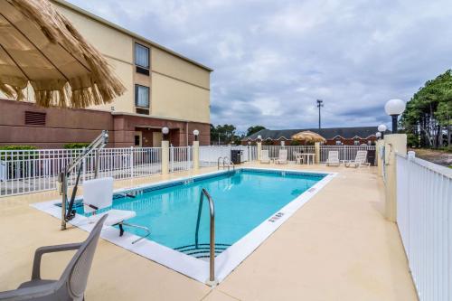 a swimming pool at a hotel with chairs around it at Comfort Inn & Suites Panama City North in Panama City